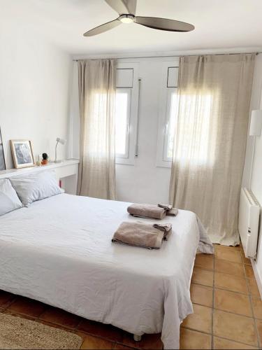 Un dormitorio con una cama blanca con toallas. en Apartment Boutique Hort, en Cadaqués