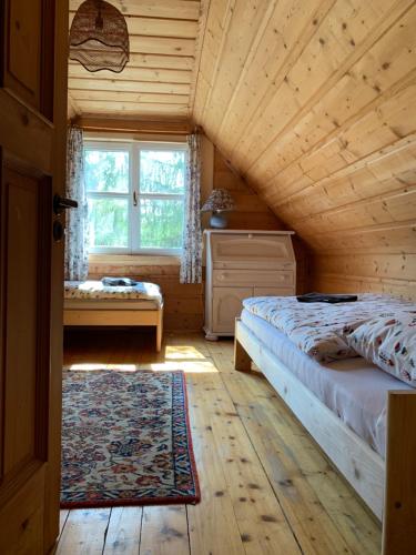a bedroom with a bed and a window in a cabin at Święty Spokój Łąka i Woda in Pozezdrze