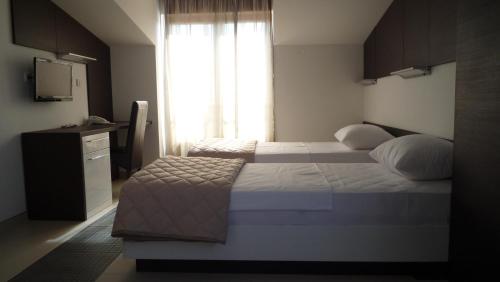 a hotel room with two beds and a window at Apartments Good Night in Niš