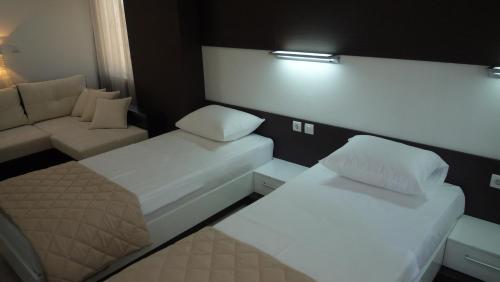 a small room with two beds and a couch at Apartments Good Night in Niš