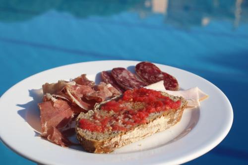 een bord met eten, een stukje cake en worstjes bij Apartaments Beach & Golf Resort in Pals