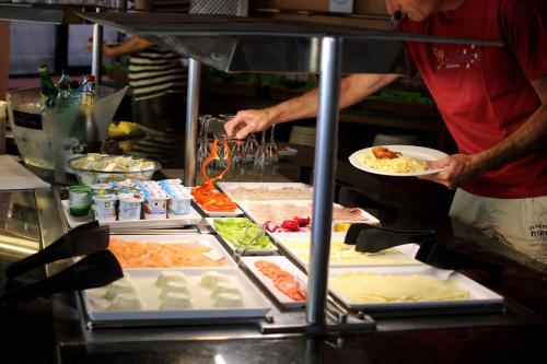 Een man met een bord eten in de keuken. bij Apartaments Beach & Golf Resort in Pals