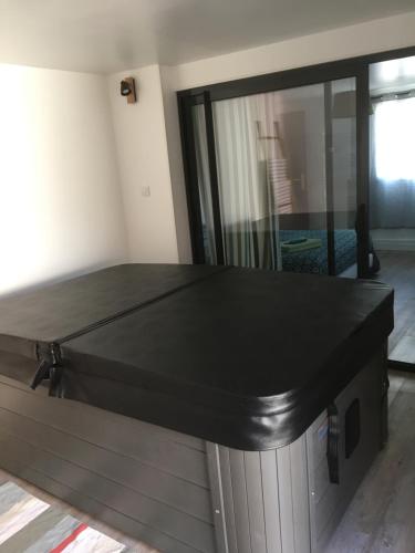 a large black table in a room with a mirror at Gîte avec jacuzzi privatif à proximité de l'océan in Saint-Julien-en-Born