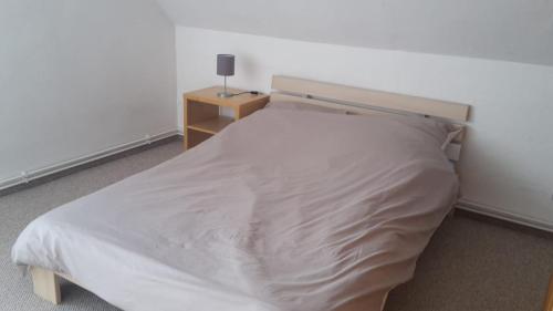 um quarto com uma cama branca e uma mesa de cabeceira em Karsdorf nahe Kanustation im Burgenlandkreis em Karsdorf