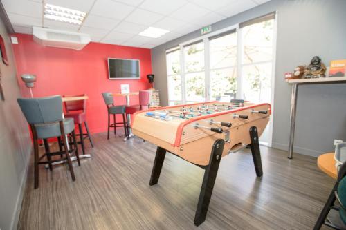 a room with a foosball table and a table at Première Classe Lyon Sud - A7 in Irigny