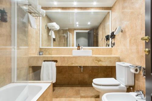 a bathroom with a toilet, sink and tub at Acta Splendid in Barcelona