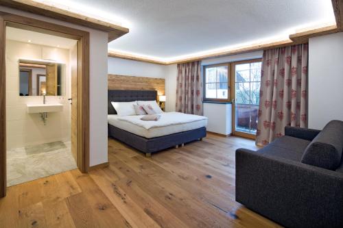 pokój hotelowy z łóżkiem i kanapą w obiekcie Blattlhof w mieście Sankt Johann in Tirol
