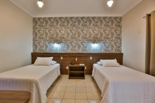 a room with two beds and a wall at Ucayali Hotel in Sinop