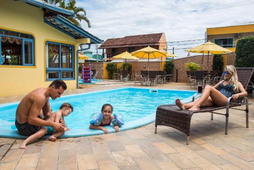 a family playing in a swimming pool at Vila Olaria Hotel in Penha