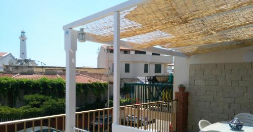 a patio with a pergola and a table on a balcony at Casa GIOLE in Punta Secca