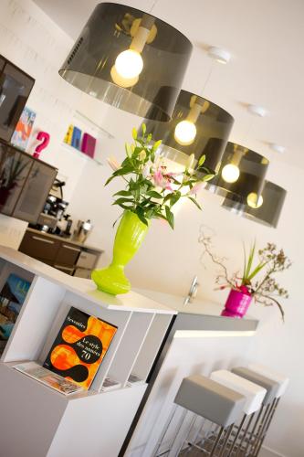 a vase with flowers on a shelf in a kitchen at Hype Hôtel in Biscarrosse