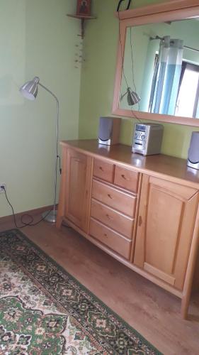 a room with a wooden dresser with a mirror at Kornatka Hajnówka Pokoje Puszcza Białowieska in Hajnówka