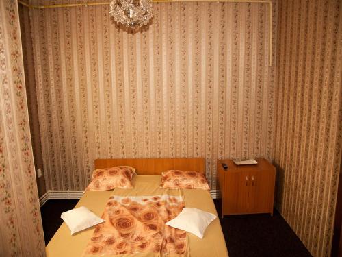 a bedroom with two beds and a chandelier at Pensiunea Contour in Iaşi