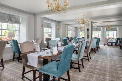 a dining room with tables and chairs and a chandelier at The King's Head in Thirlmere