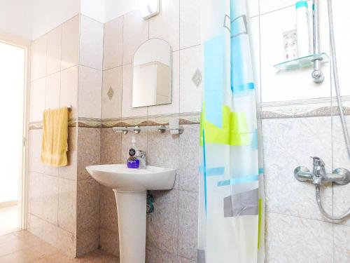 a bathroom with a sink and a shower at RiX Sunny Apartments in Kérynia