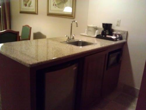 a kitchen counter with a sink and a coffee maker at AmericInn by Wyndham Omaha in Omaha