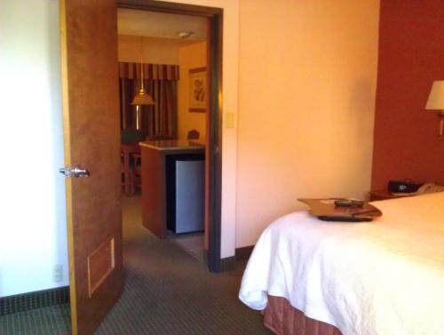 a room with a bed and a room with a table at AmericInn by Wyndham Omaha in Omaha
