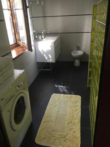 a bathroom with a washing machine and a sink at Svetlana Guest House in Novy Afon