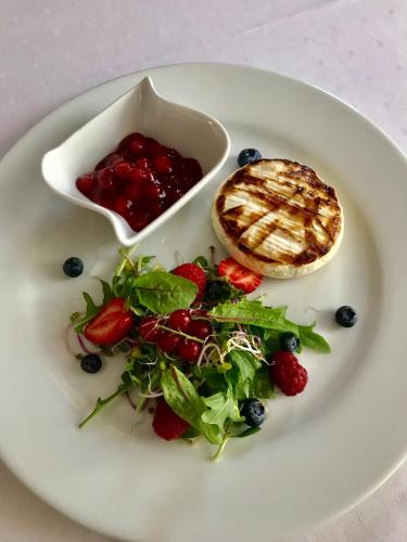 a plate of food with a salad and sauce at Neptun in Międzychód