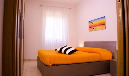 ein Schlafzimmer mit einem orangenen Bett mit einem Kissen darauf in der Unterkunft Butterfly casa vacanze in Sutri