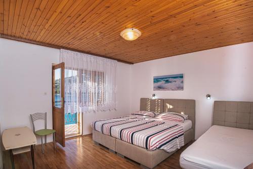 1 dormitorio con cama, mesa y ventana en Apartments Stokic, en Donja Klada