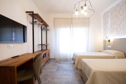 Habitación con 2 camas, escritorio y TV. en B&B Poggiobonizio, en Poggibonsi