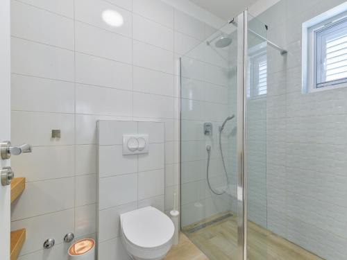 une salle de bain blanche avec douche et toilettes dans l'établissement Luxury sea view villa Biograd, à Biograd na Moru