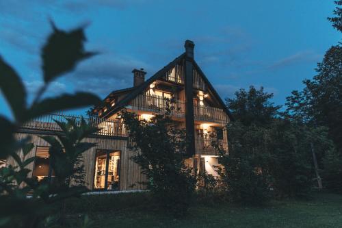 a large house at night with its lights on at Hotel Majerca in Bohinj