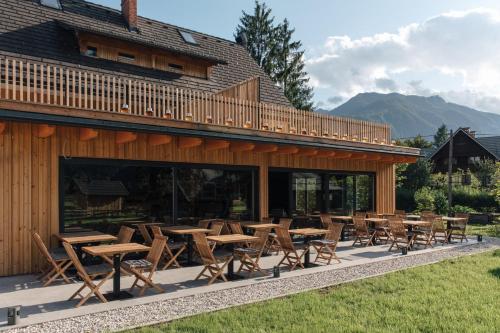 a group of tables and chairs in front of a building at Hotel Majerca in Bohinj