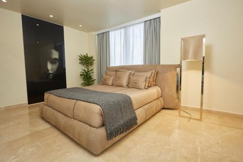 アクラにあるKwarleyz Residence Hotel & Suitesの大きなベッドとソファのある寝室
