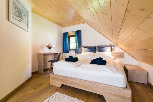1 dormitorio con 1 cama blanca grande y techo de madera en ŻŁOBINA Apartament, en Wisła
