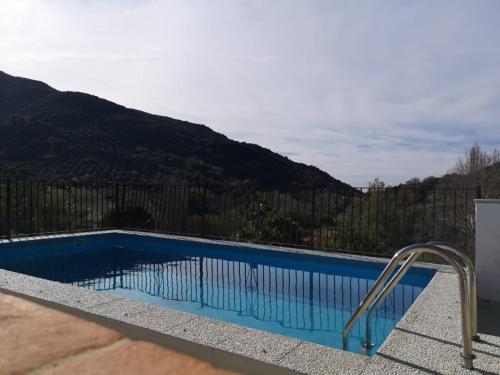 uma piscina com vista para uma montanha em La Fuente De El Nacimiento em Benamahoma