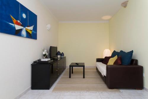 una sala de estar con un sofá y una mesa en Boas-Vindas, en Albufeira
