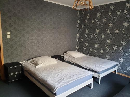 Habitación con 2 camas individuales y papel pintado con motivos florales. en Viktor, en Pirmasens