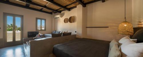 Un dormitorio con una cama y una sala de estar. en Misteli Suites, en Akrotiri