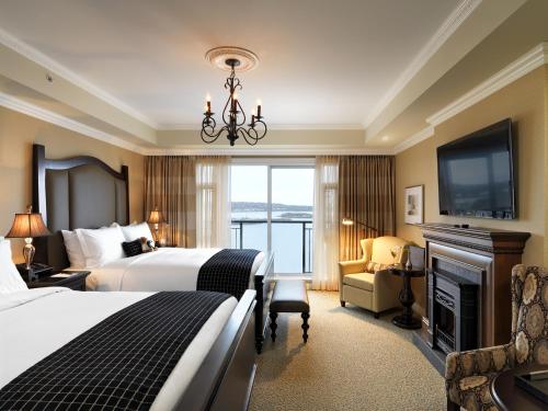 a hotel room with a large bed and a fireplace at Oak Bay Beach Hotel in Victoria
