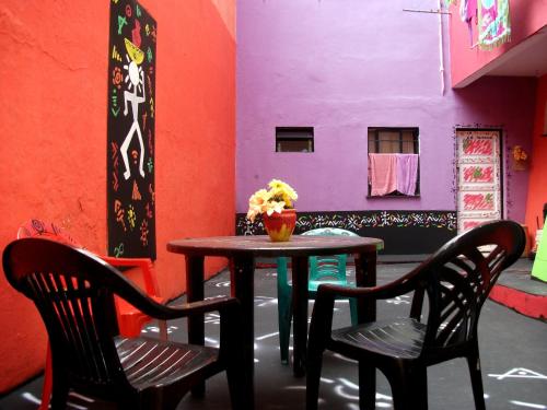 a table and chairs in a room with a purple wall at Arte Brasileira in Salvador