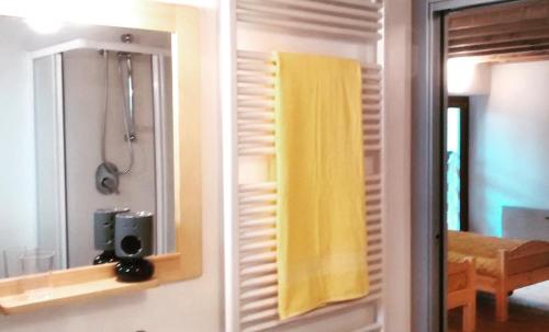 a bathroom with a yellow shower curtain and a mirror at Ostello Sociale Borgo Venno in Lavenone