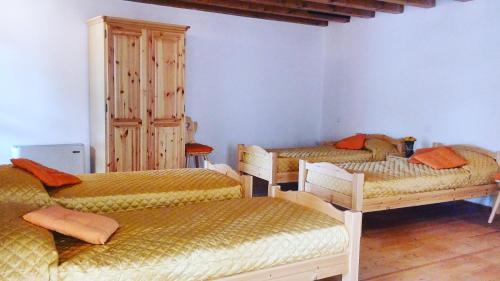 a room with three beds with orange pillows at Ostello Sociale Borgo Venno in Lavenone