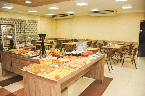 una línea de buffet con muchos tipos diferentes de comida en Larison Hotéis - Porto Velho en Porto Velho