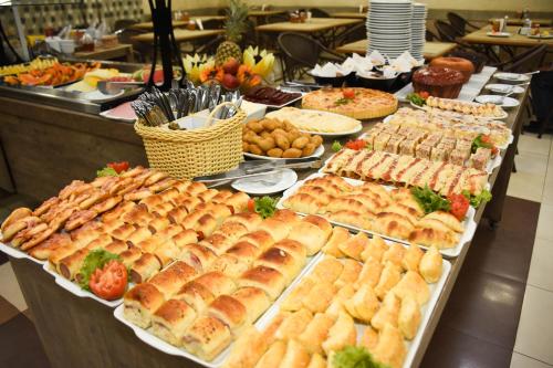 a buffet with many different types of sandwiches and pastries at Larison Executive by Easy Hotéis in Porto Velho