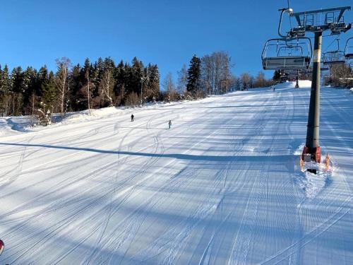 a ski lift with people skiing down a snow covered slope at ProFamily Hotel TOP Benecko in Benecko