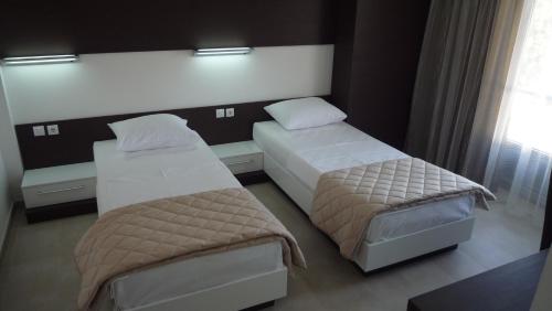 a bedroom with two beds and a window at Apartments Good Night in Niš