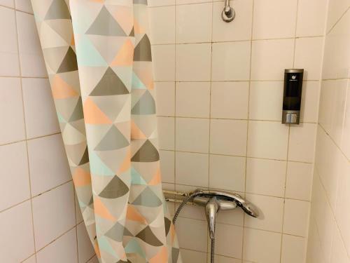 La salle de bains est pourvue d'une douche et de murs en carrelage géométrique. dans l'établissement Granet Studio, à Aix-en-Provence