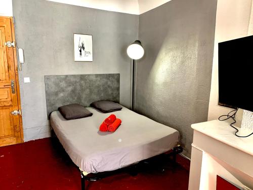 une chambre avec un lit avec deux oreillers rouges dessus dans l'établissement Granet Studio, à Aix-en-Provence