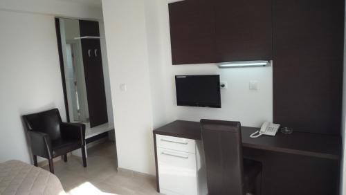 a room with a desk with a computer and a phone at Apartments Good Night in Niš