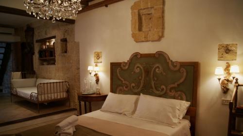 una camera con letto, sedia e lampadario a braccio di Corte Serra a Bari