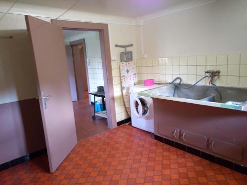a kitchen with a sink and a washing machine at do mi si la do ré in Exincourt
