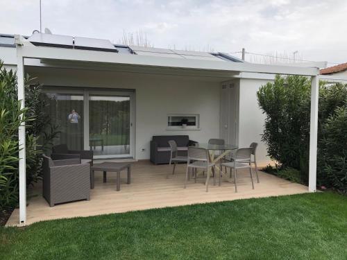 a patio with a table and chairs on a deck at Maribeach in Cavallino-Treporti