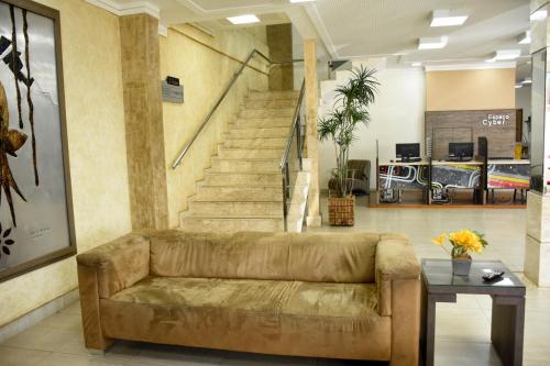 a living room with a couch and stairs at Larison Executive by Easy Hotéis in Porto Velho